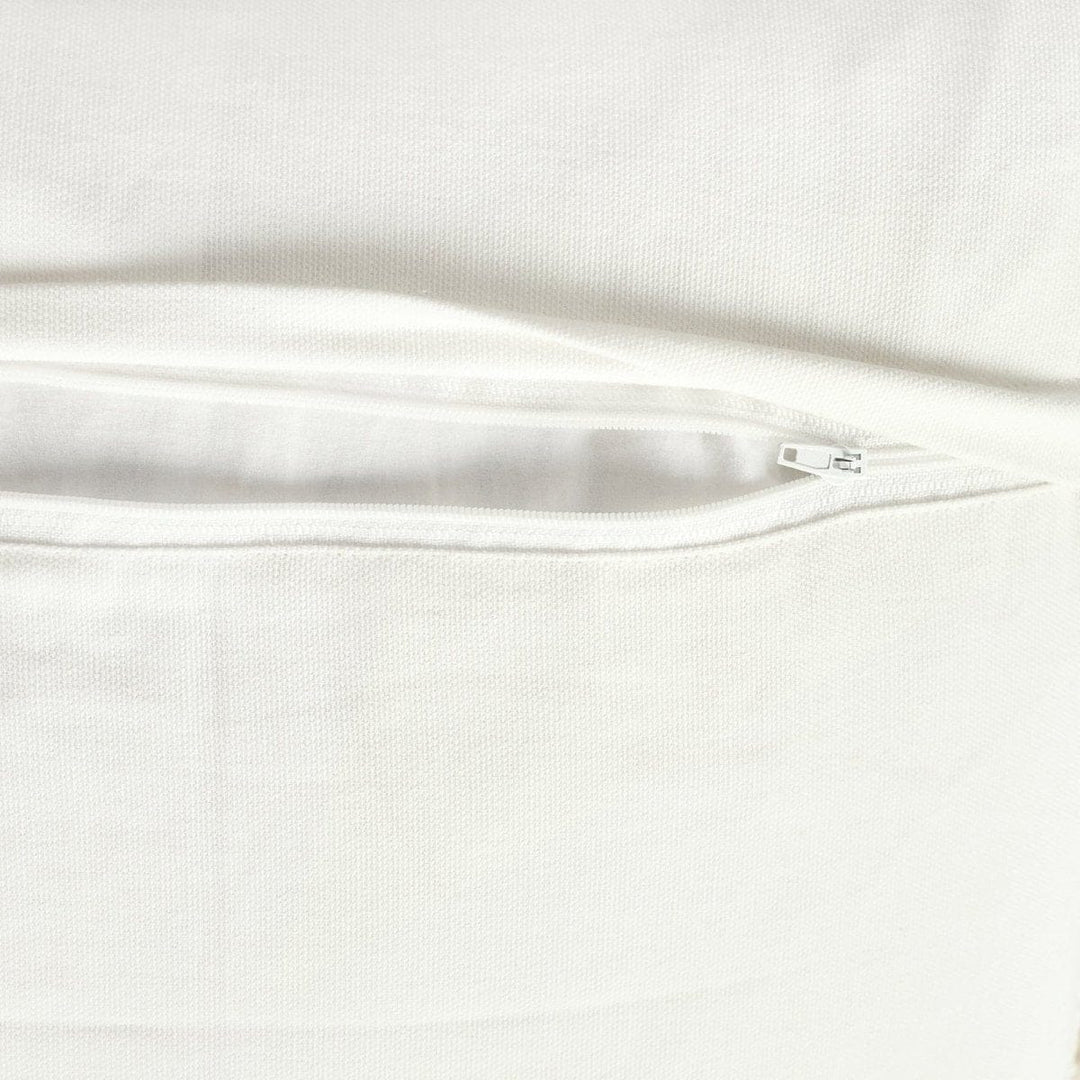 Ivory and neutral tufted cotton pillow cover in a layered home decor setting